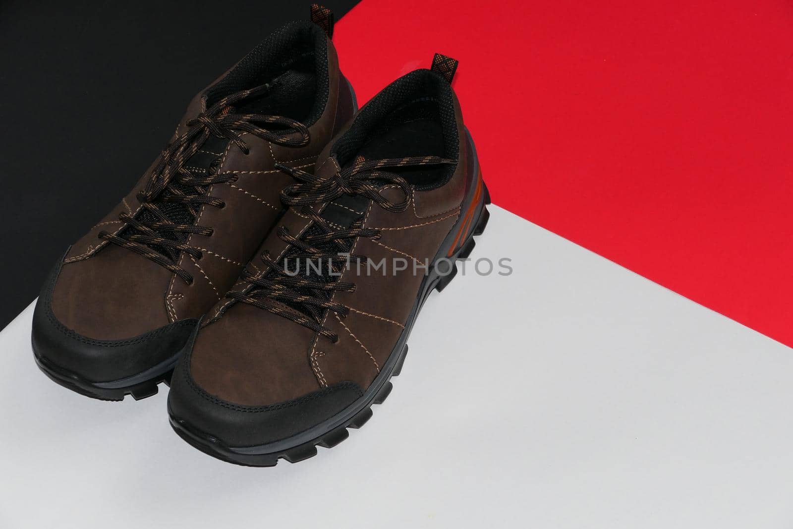 Stylish men's sneakers or leather brown shoes on a colored background.