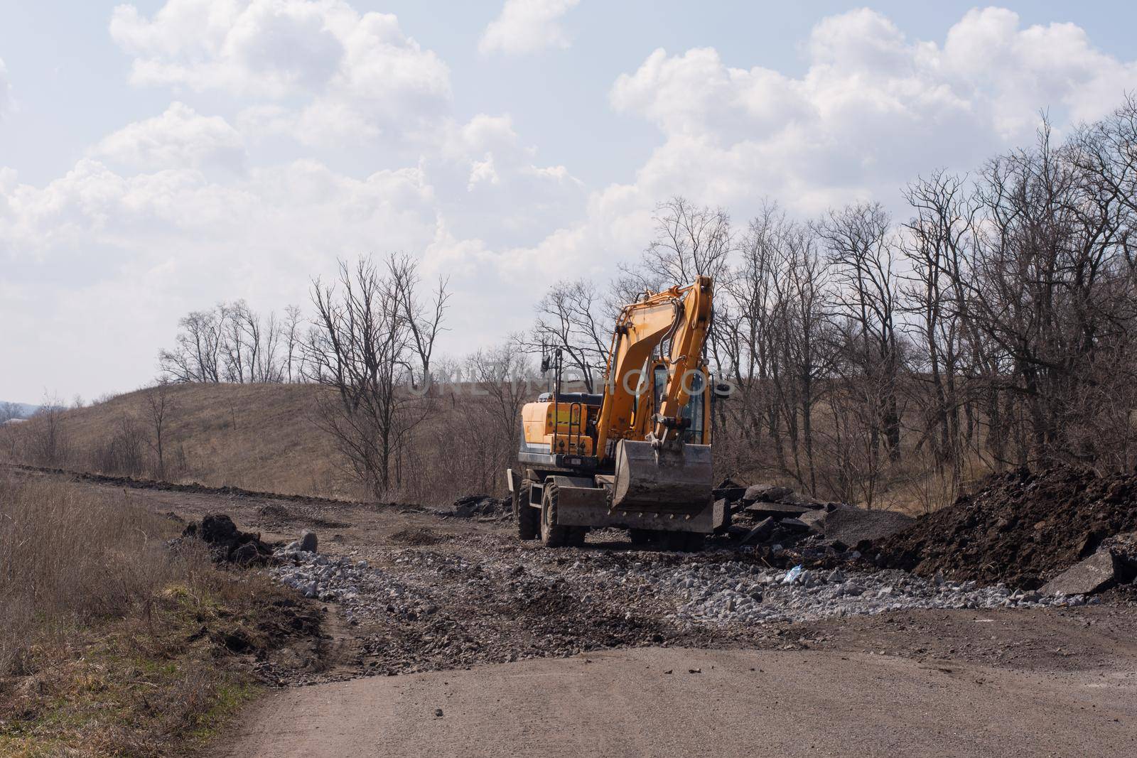 Excavator at the road construction out of city. Road construction roads.