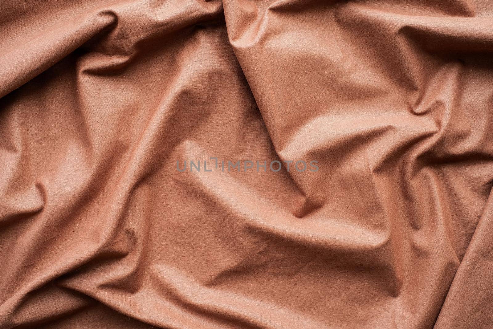 Closeup of rippled brown silk fabric. Abstract texture background