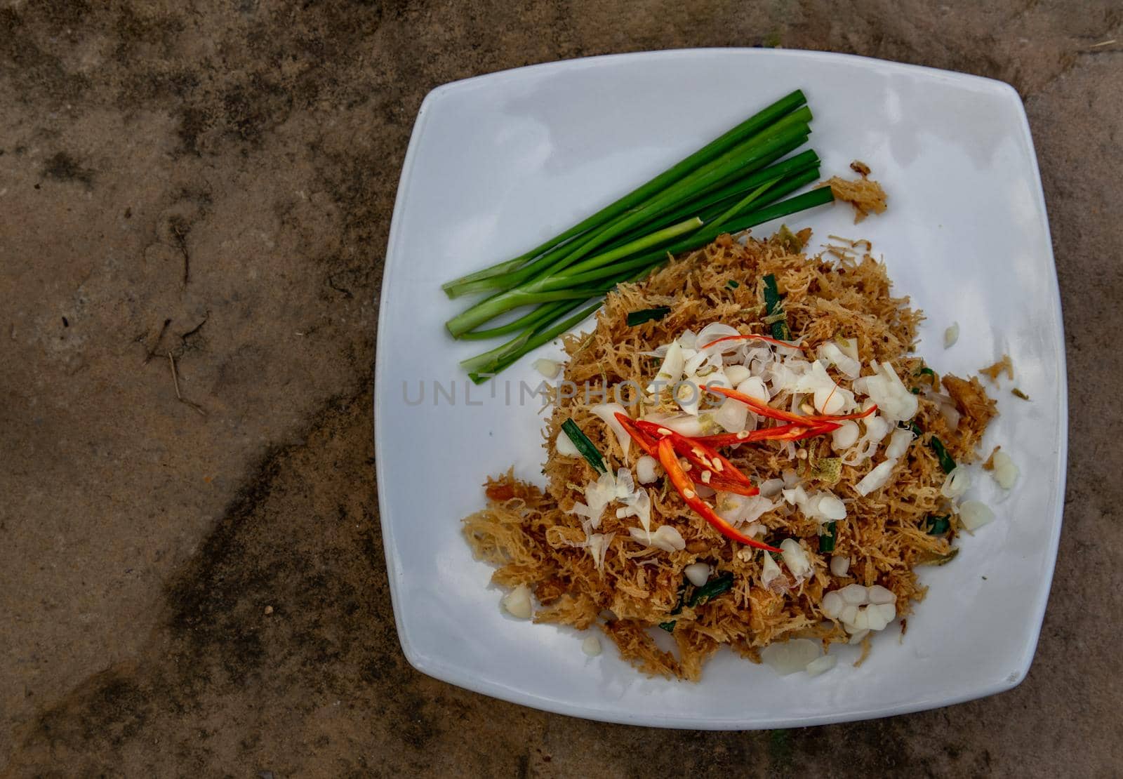Asian eating food, Mee Grob is an sweet and sour crispy noodles, made from Thai rice noodle with sweet and sour sauce on white plate, Sweet & Sour Crispy Rice Noodles, Top view.