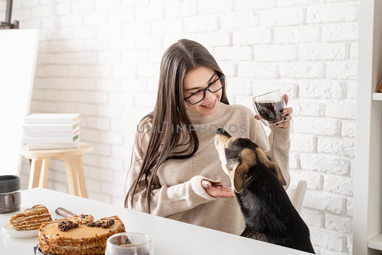 Alternative coffee brewing. Young brunette woman drinking hot black coffee sitting at the white table