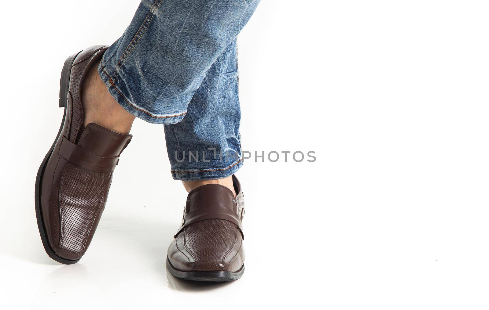 Close up of man leg in jeans with leather shoes isolated on white background