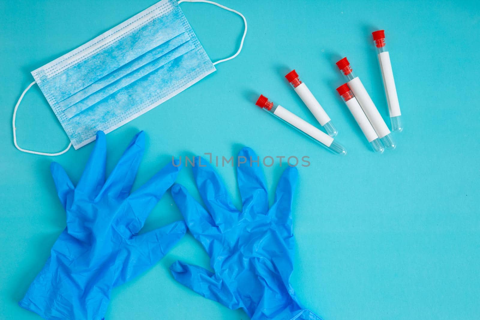 Medical test tubes, face mask, gloves on blue background. Vaccination.