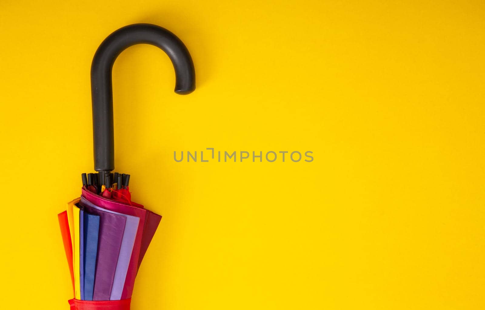 Fragment of umbrella hook on yellow background. Top view. Autumn accessories. by tehcheesiong