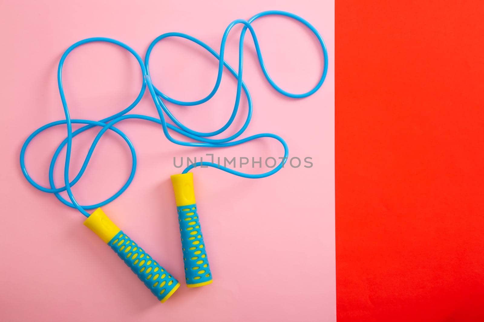 Minimalism fitness concept. Skipping rope on color background. Top view