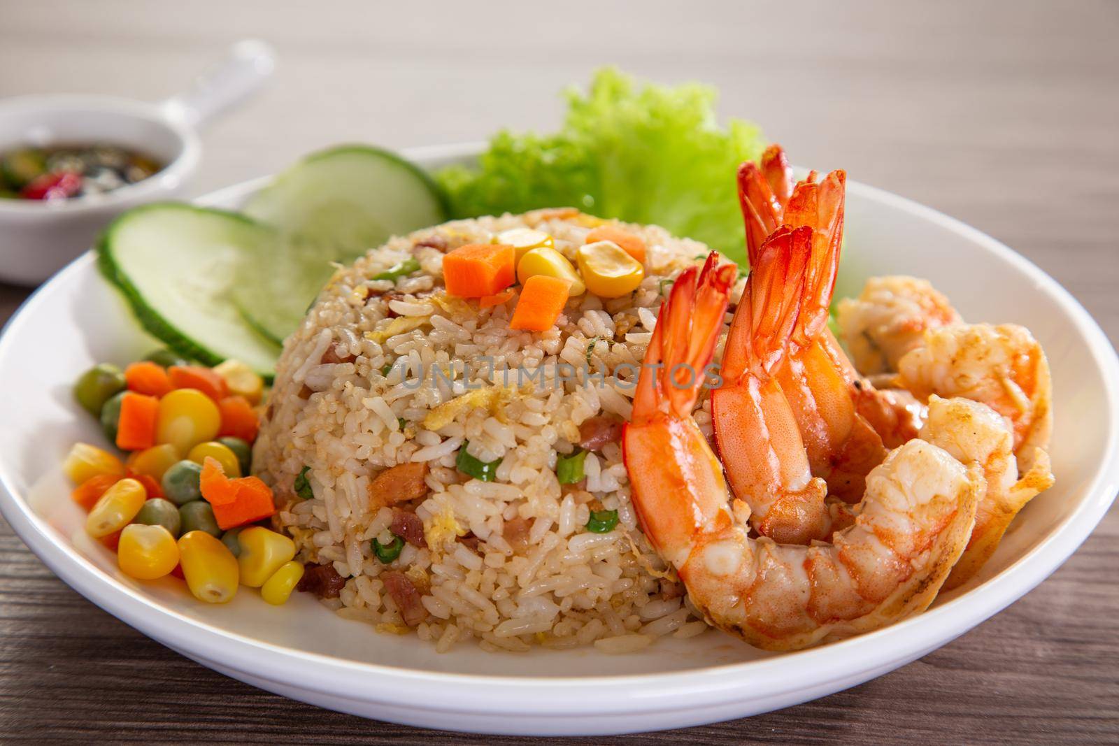 chinese fried rice with barbecue prawn on wooden table by tehcheesiong