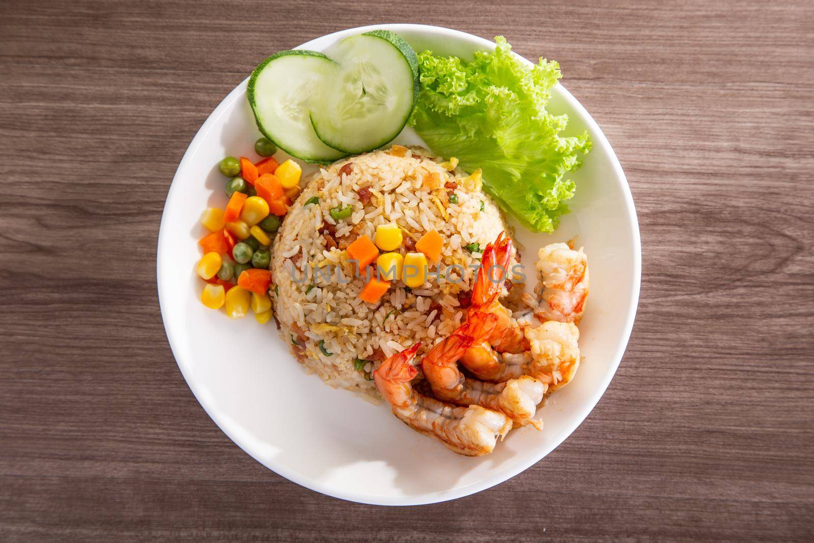 chinese fried rice with barbecue prawn on wooden table by tehcheesiong