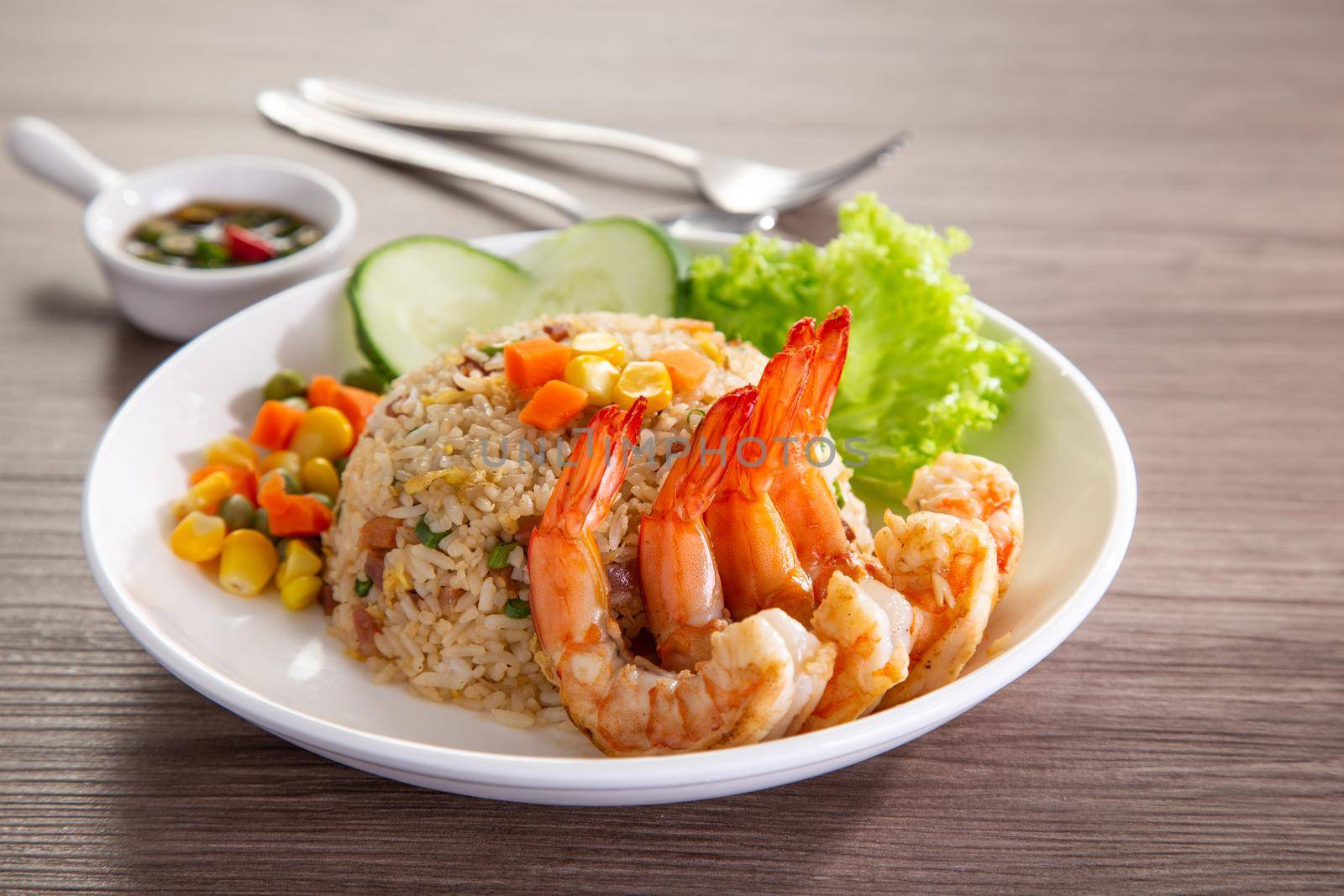 chinese fried rice with barbecue prawn on wooden table by tehcheesiong