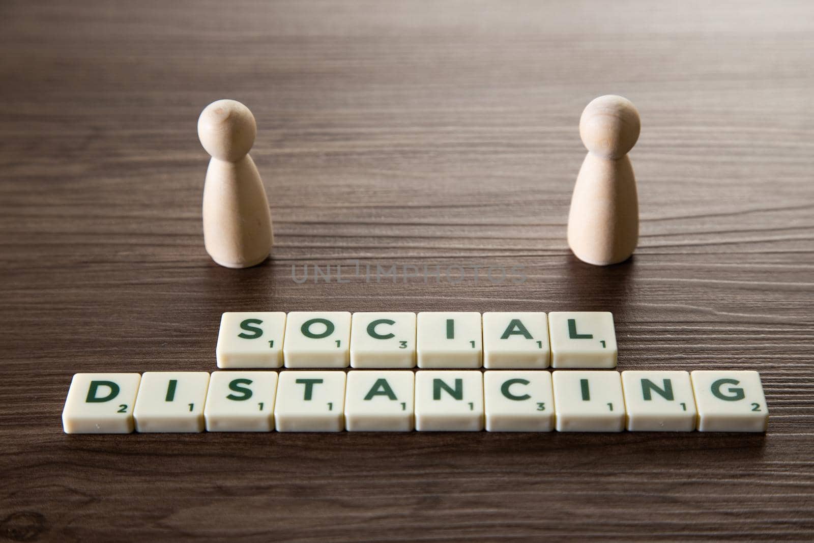 Conceptual image about social distancing, mandatory due to the coronavirus outbreak, covid-19. Pair of wooden human figures standing with distancing
