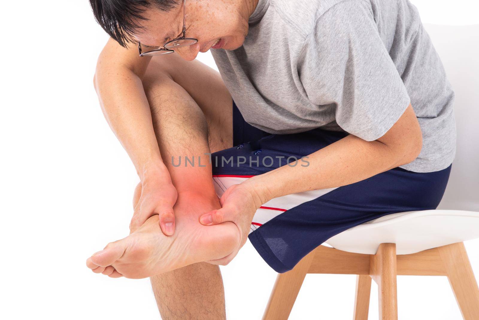 Sore pain of ankle. Sprain and arthritis symptoms. middle age man holding his hurt ankle by tehcheesiong