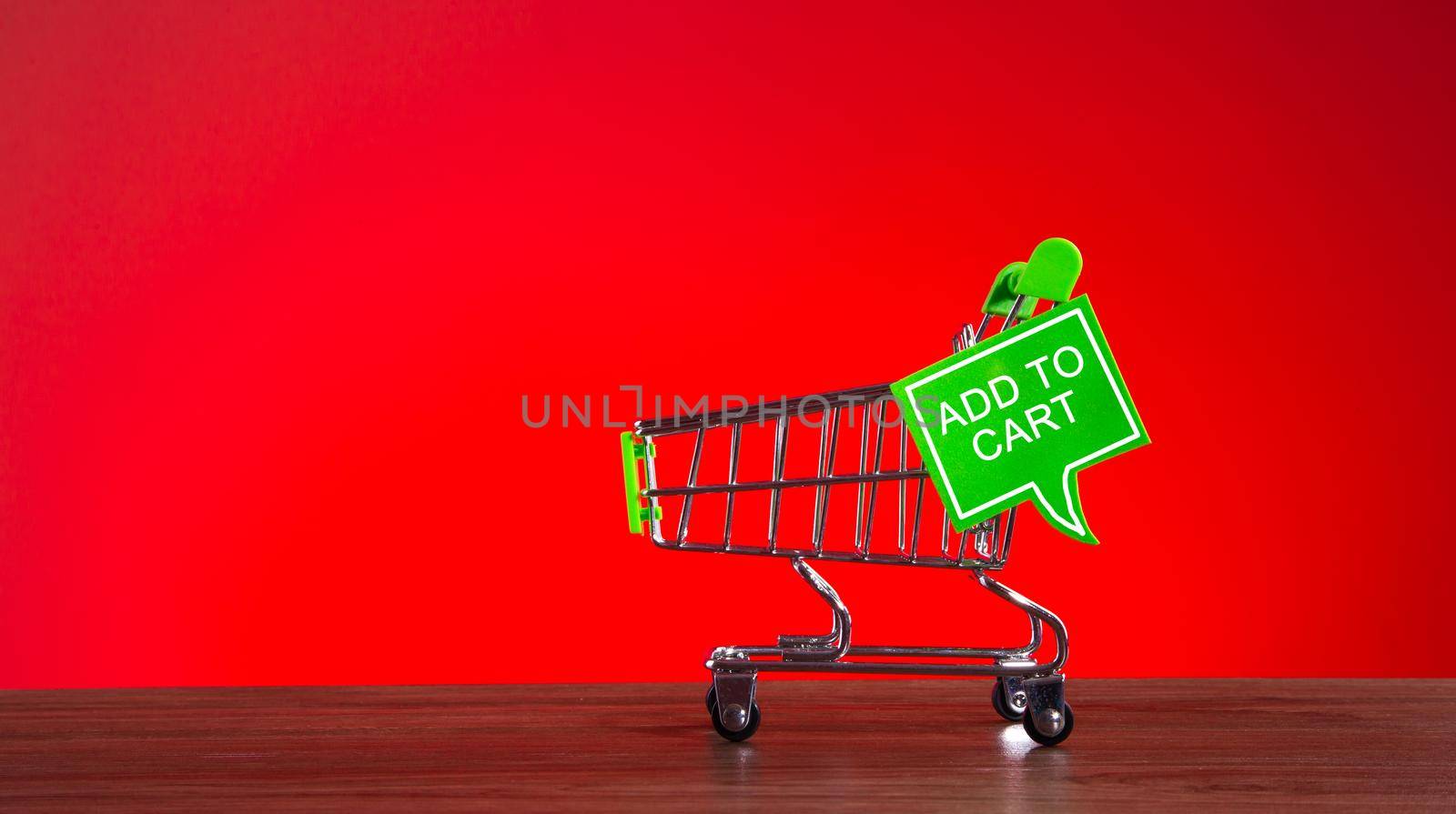 Tiny shopping cart with the word ADD TO CART in speech bubble. Add to cart shopping conceptual.