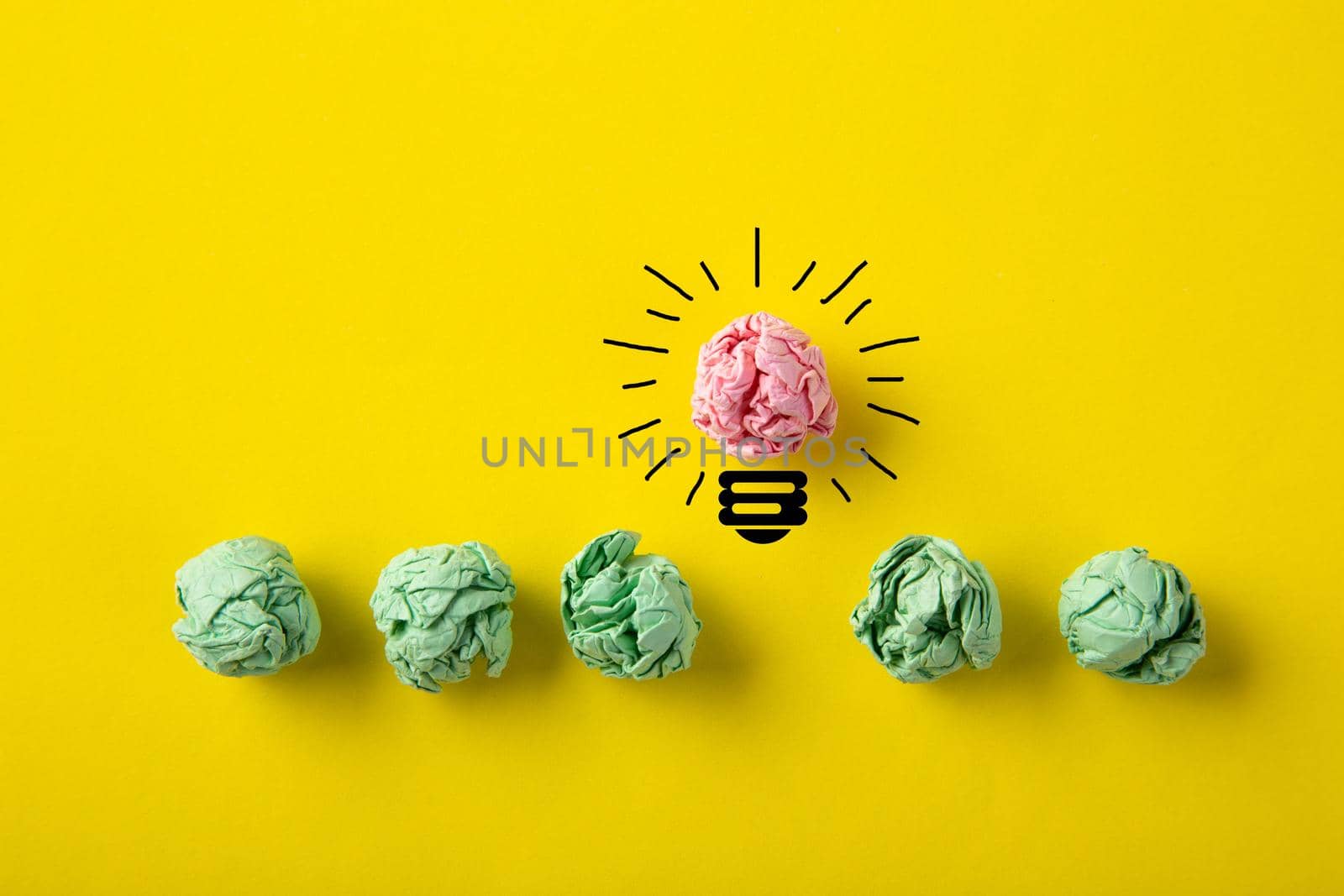 Inspiration concept crumpled paper light bulb metaphor for good idea on yellow background