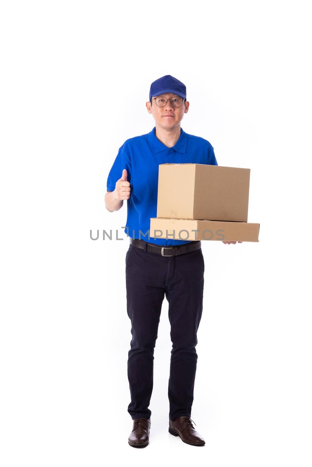 young Asian delivery man in blue uniform, carry cardboard box in hands isolated on white background. by tehcheesiong