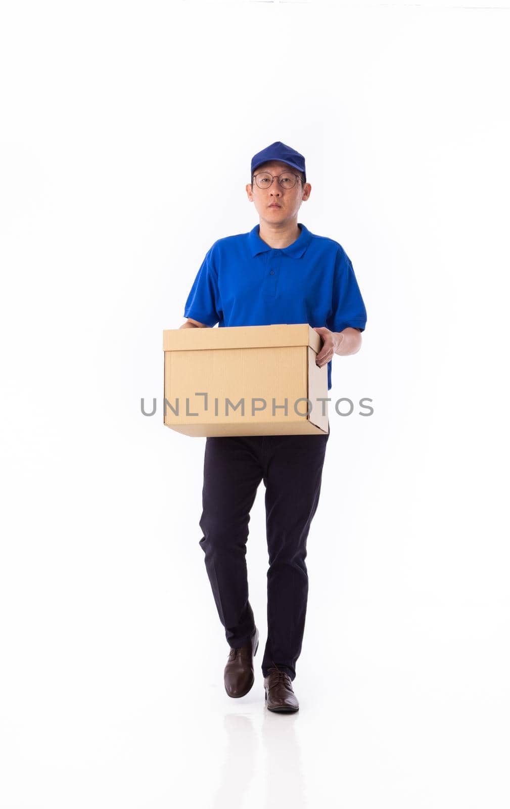 young Asian delivery man in blue uniform, carrry cardboard box in hands isolated on white background by tehcheesiong