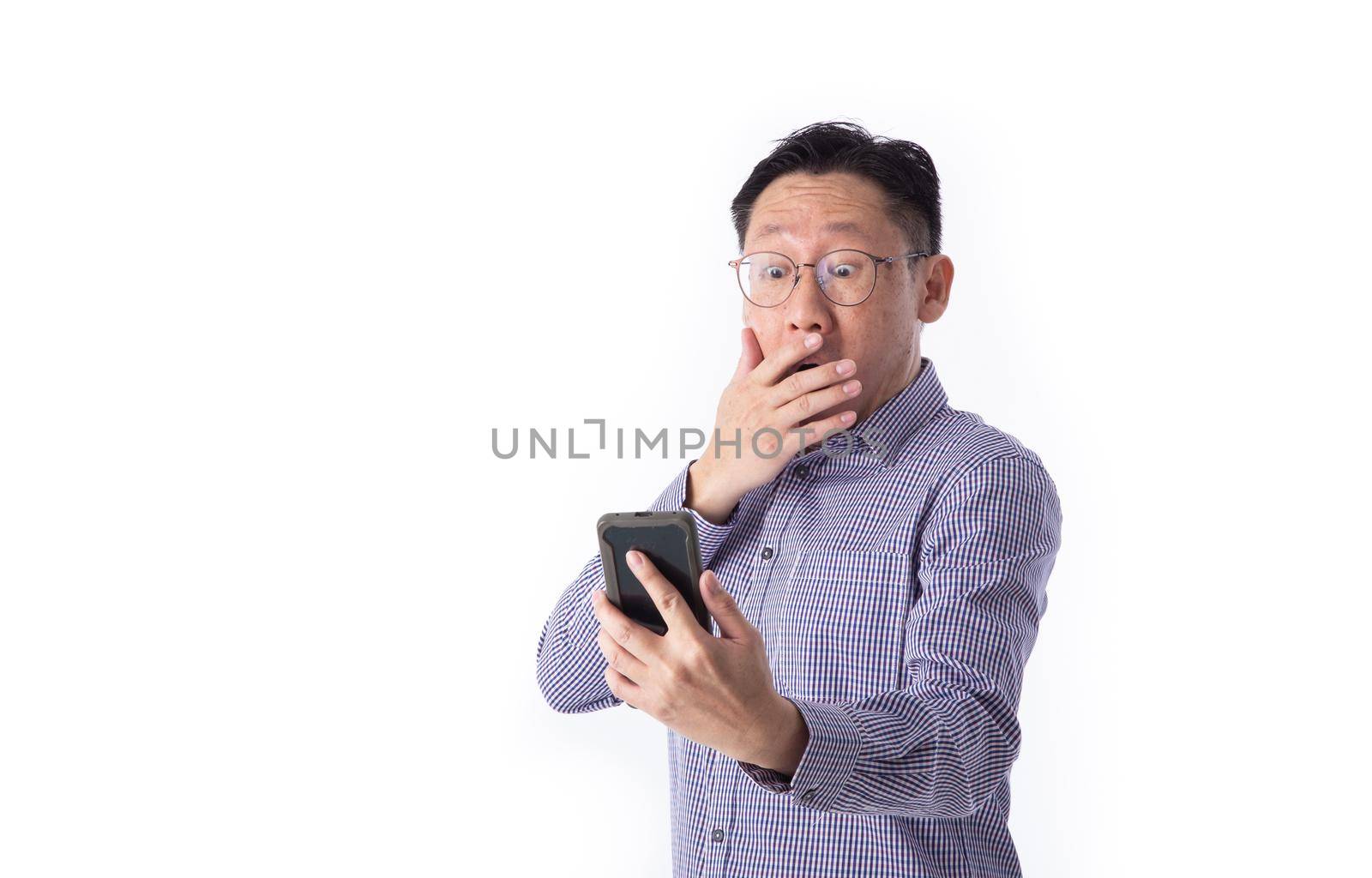 Surprised face of Asian man shocked what he see in the smartphone on isolated white background.