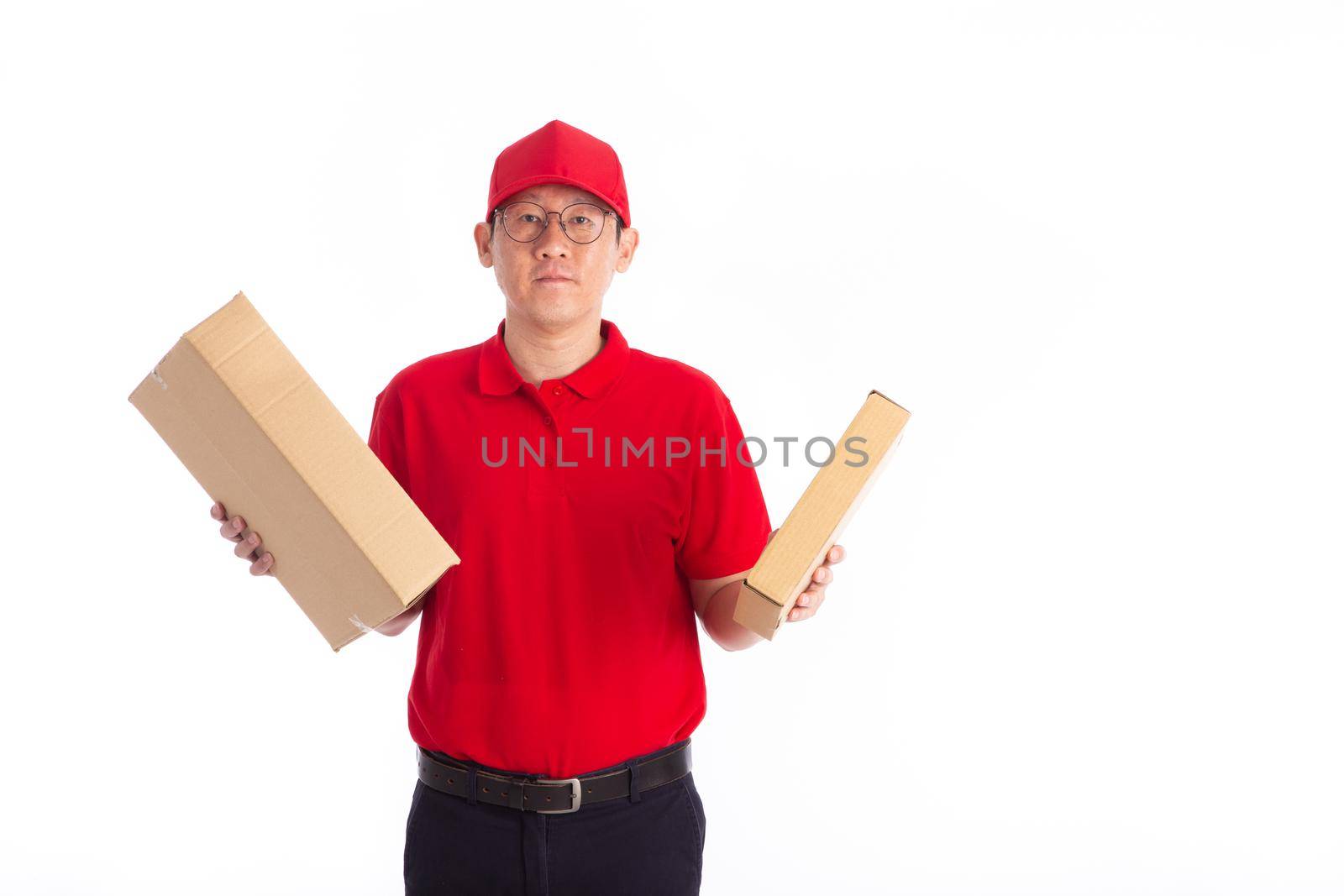 young Asian delivery man in red uniform, carry cardboard box in hands isolated on white background. by tehcheesiong