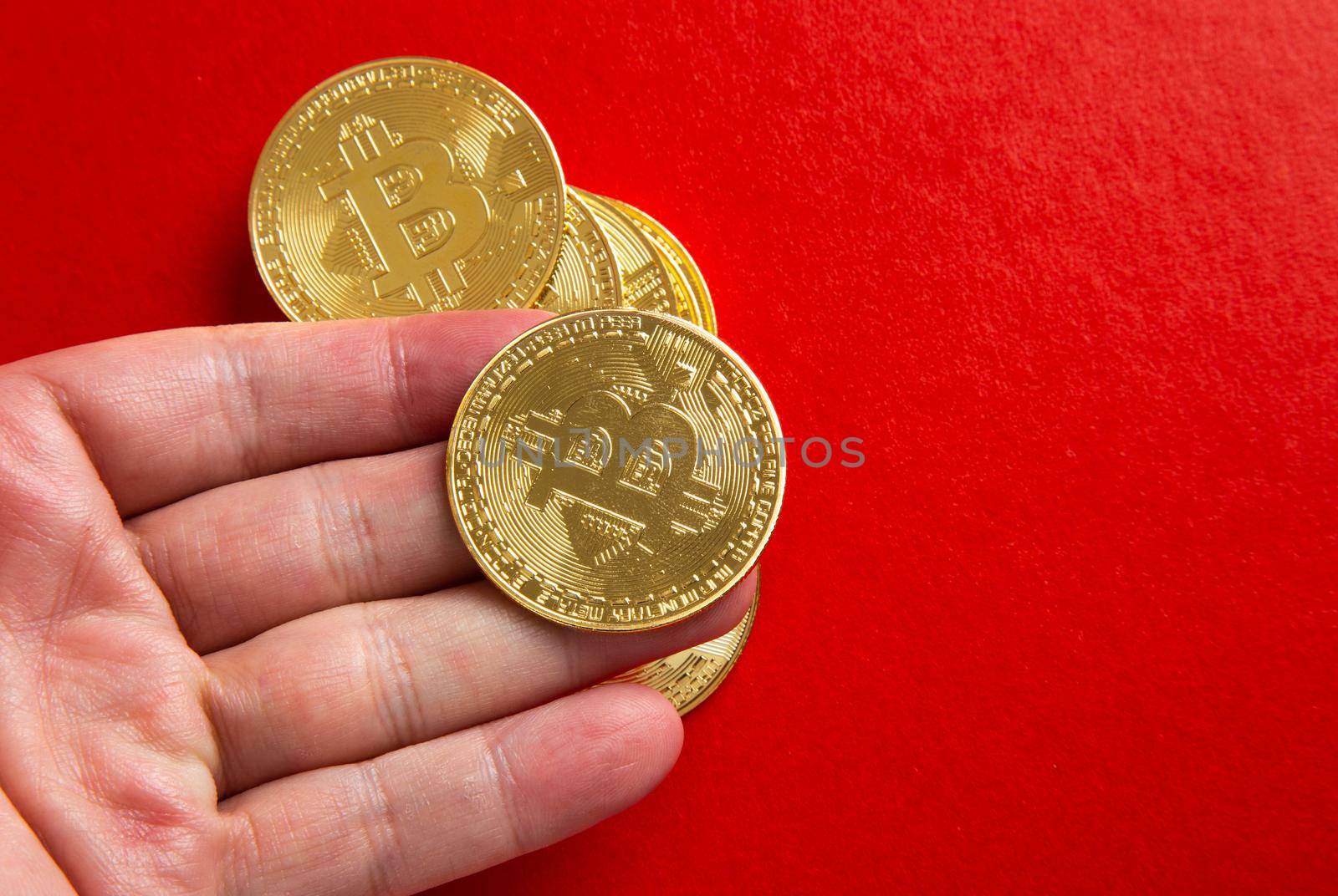 Man Hand holding a bitcoin on red background