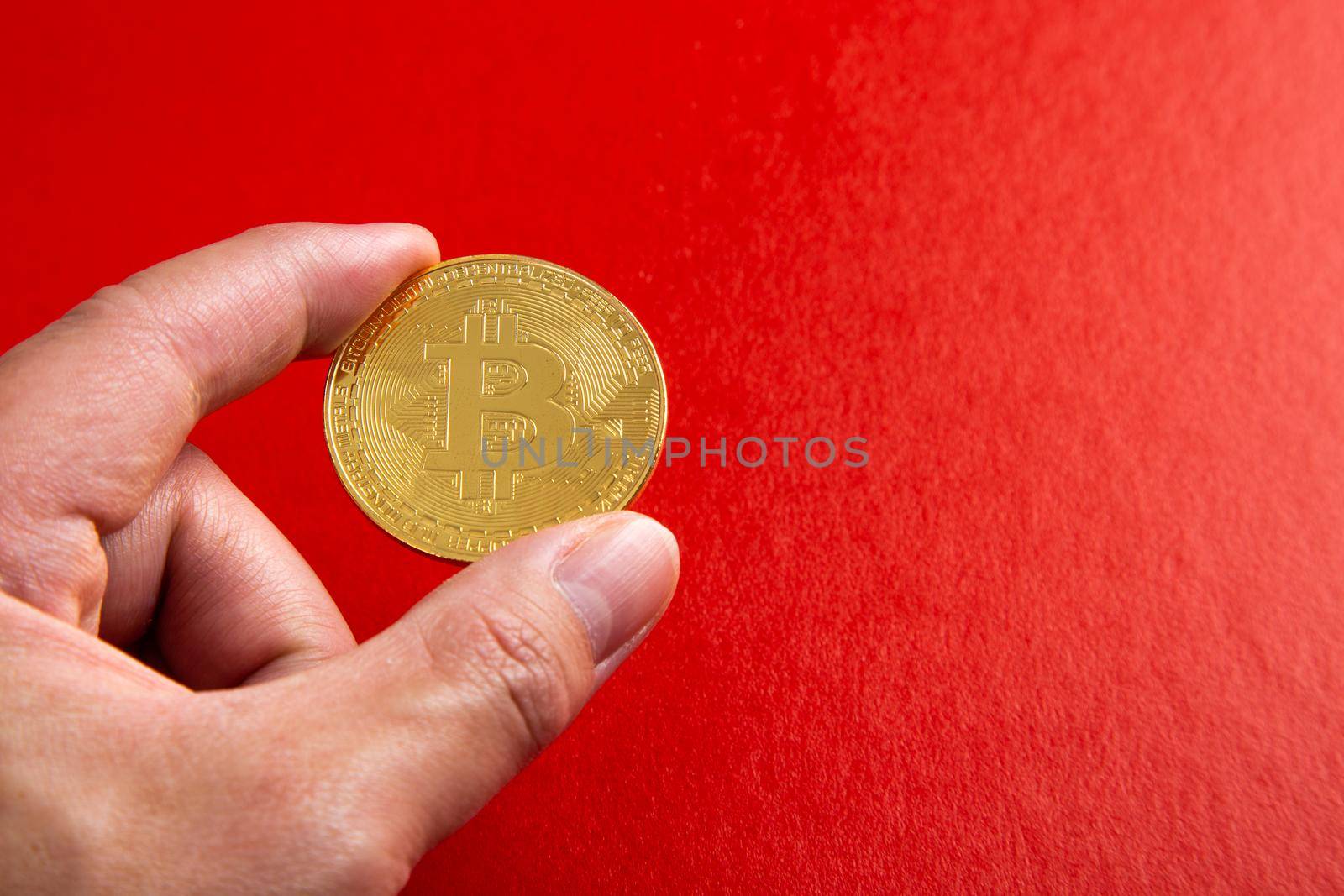 Man Hand holding a bitcoin on red background