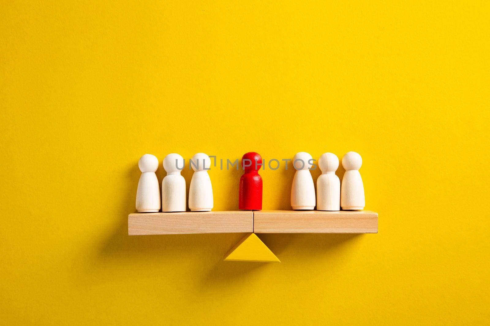 The leader stands on the scales between two groups of people. Resolving conflict situations. The union of two opposing groups of people. Conflict of interest.