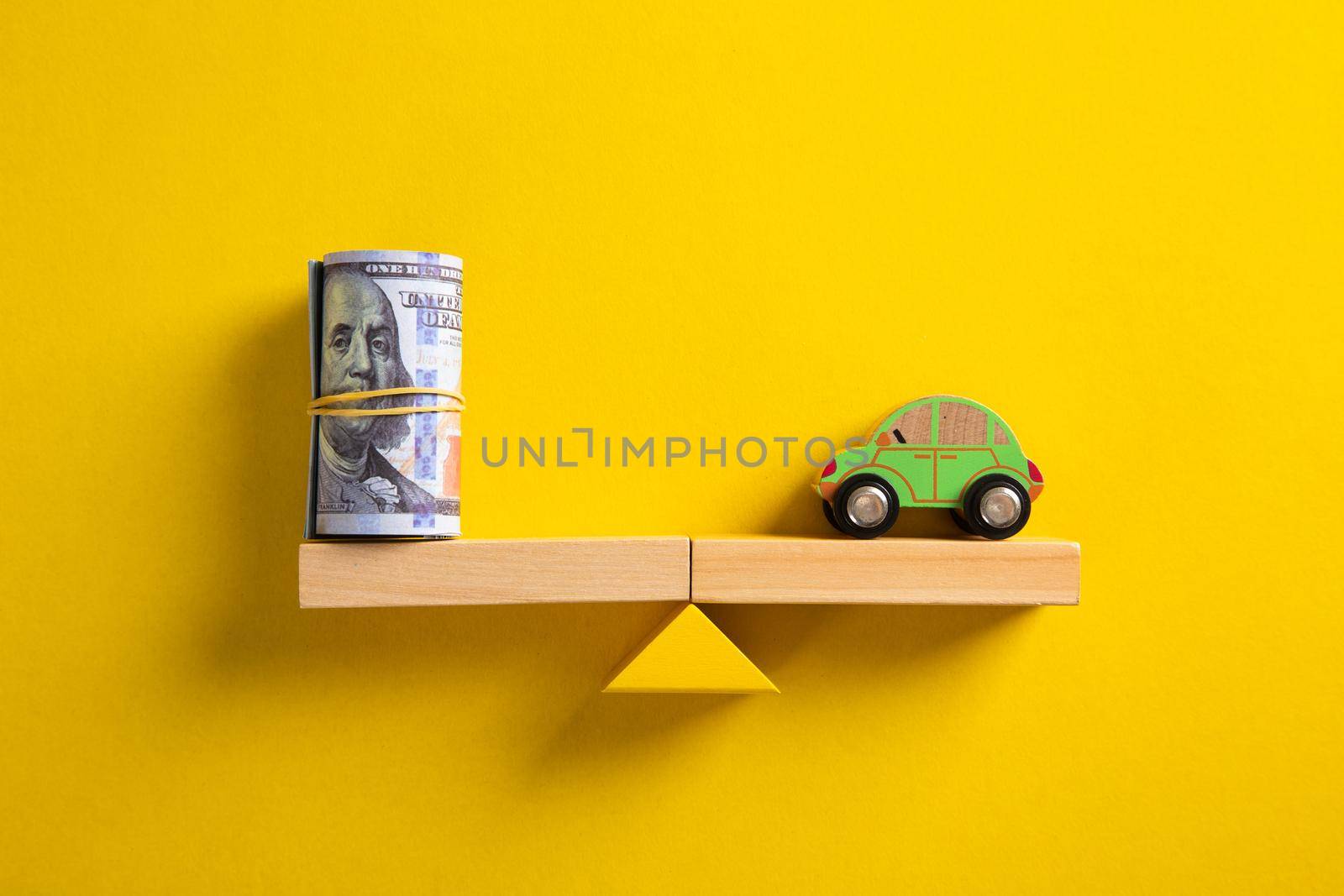 Car / Auto loan or transforming assets into cash concept : Car model, US dollar notes in jute bags on simple balance scale, depicts car owner or borrower turns personal properties into cash or wealth.