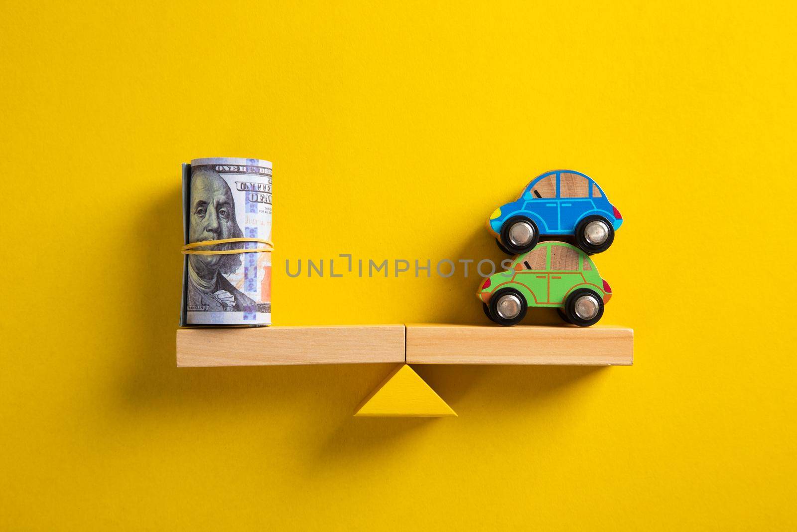 Car / Auto loan or transforming assets into cash concept : Car model, US dollar notes in jute bags on simple balance scale, depicts car owner or borrower turns personal properties into cash or wealth.