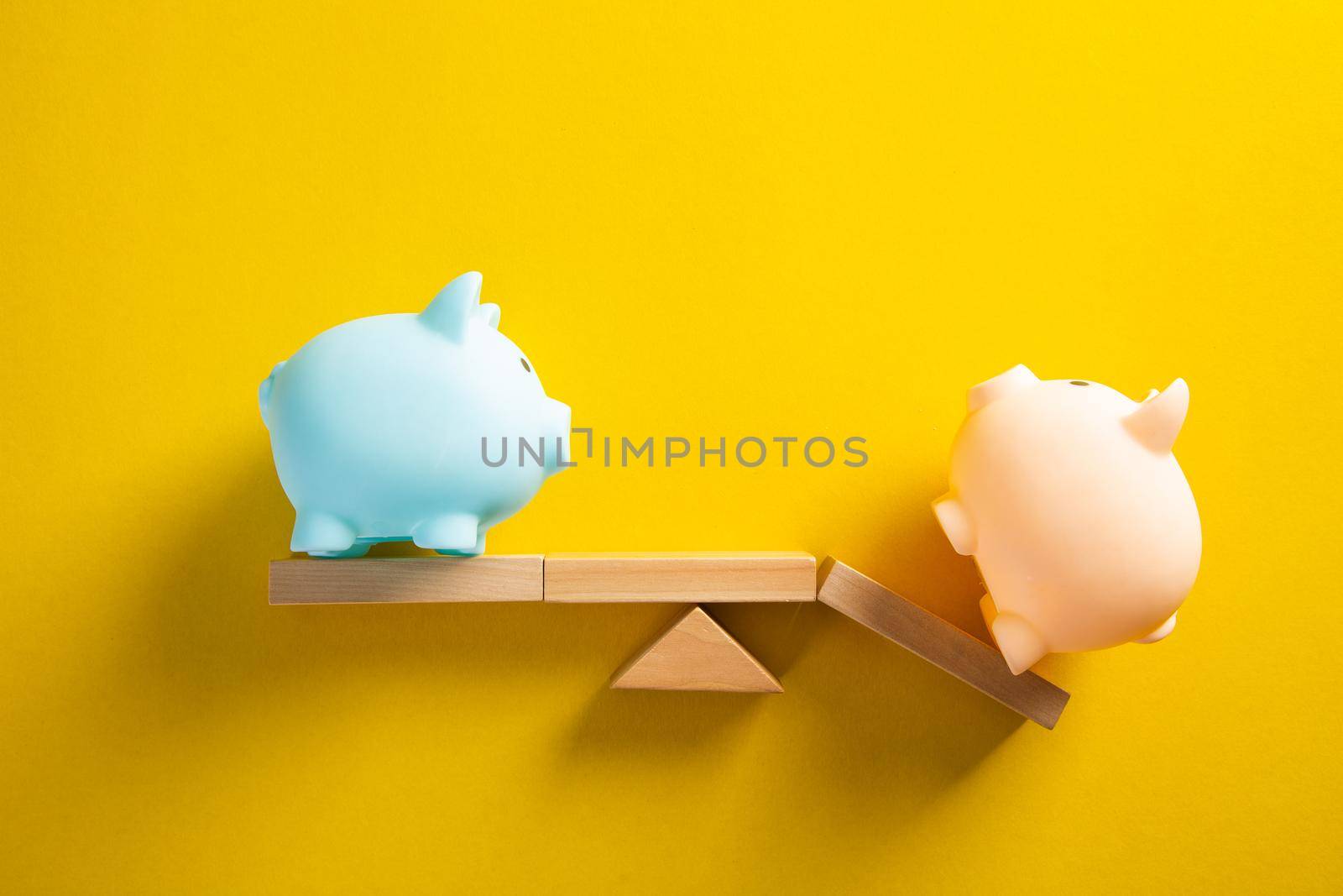 Piggy bank balancing on seesaw