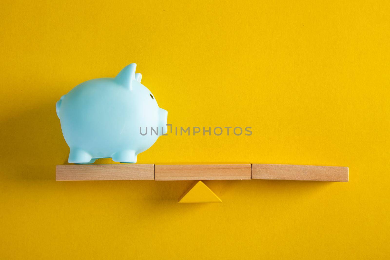 Piggy bank balancing on seesaw