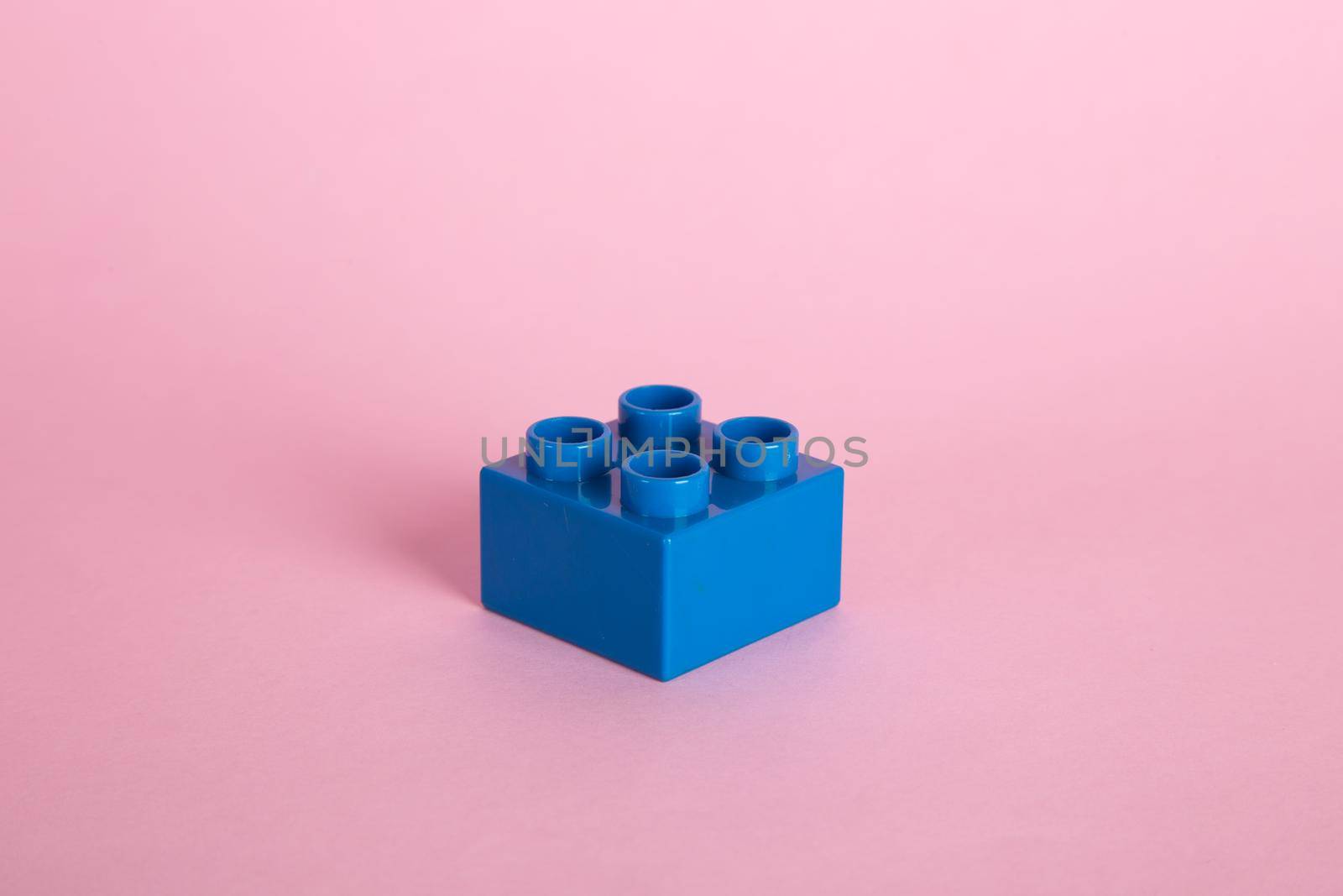 Plastic building blocks on pink background