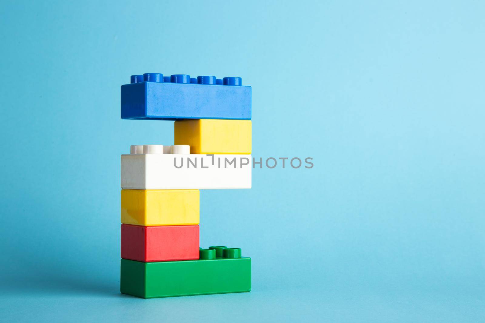 Plastic building blocks on blue background