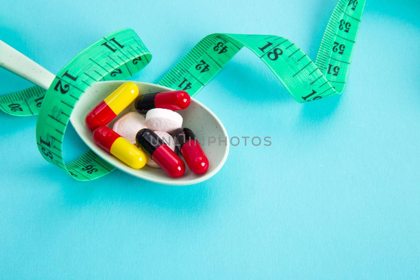 Measuring tape and pills for dieting concept. EKG medical health care and prevention.