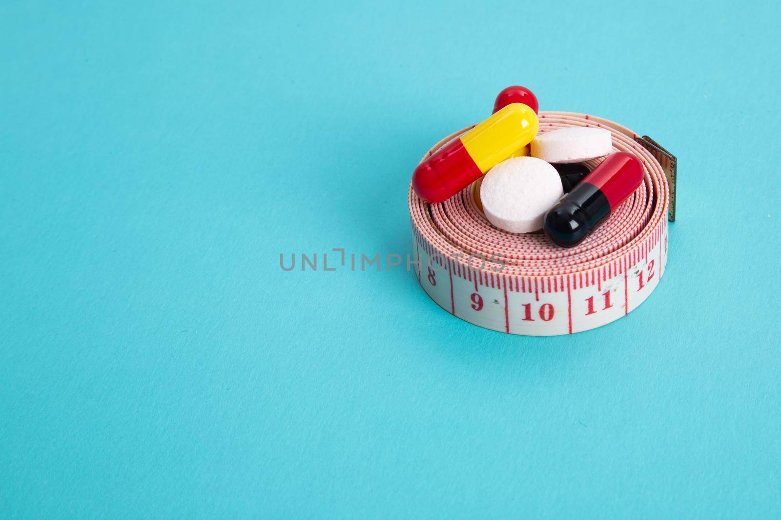 Measuring tape and pills for dieting concept. EKG medical health care and prevention.