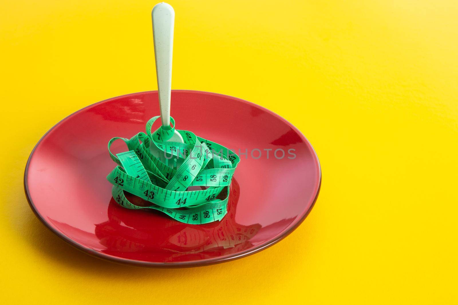 Diet for weight loss concept. Proper nutrition. Empty plate with fork and measuring tape.