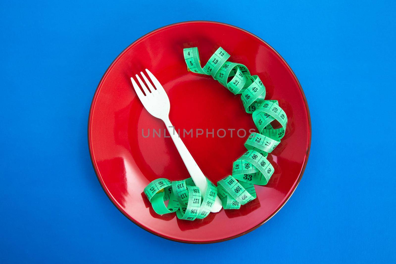 Diet for weight loss concept. Proper nutrition. Empty plate with fork and measuring tape.