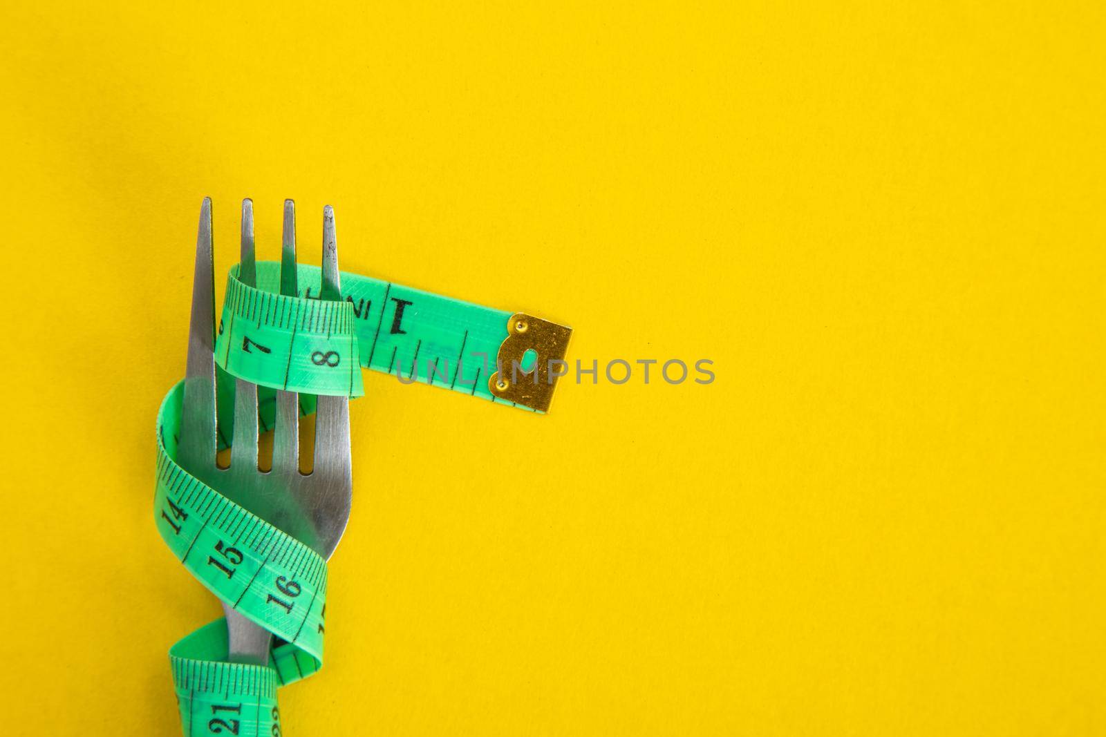 Proper nutrition for slimming. Fork with wound measuring tape. Diet Concept