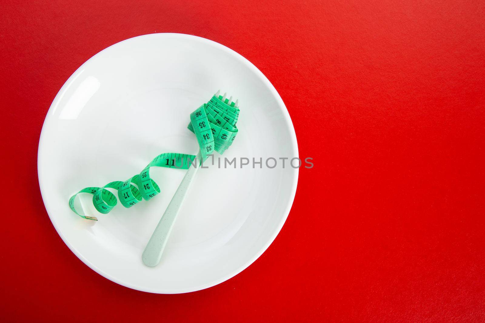 Diet for weight loss concept. Proper nutrition. Empty plate with fork and measuring tape.