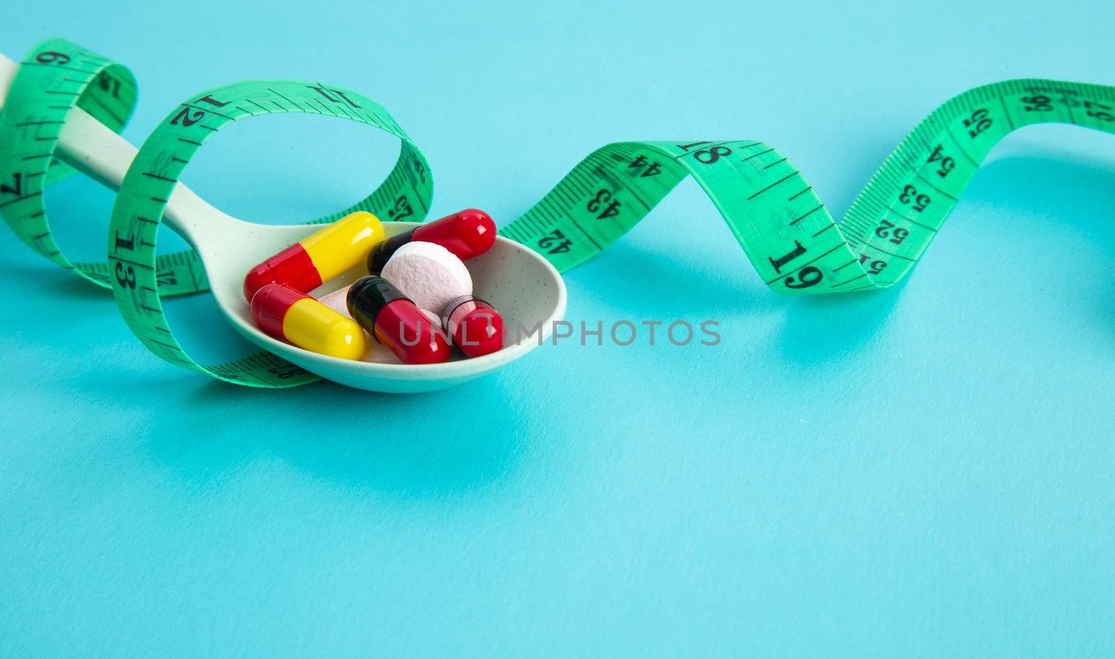 Measuring tape and pills for dieting concept. EKG medical health care and prevention.