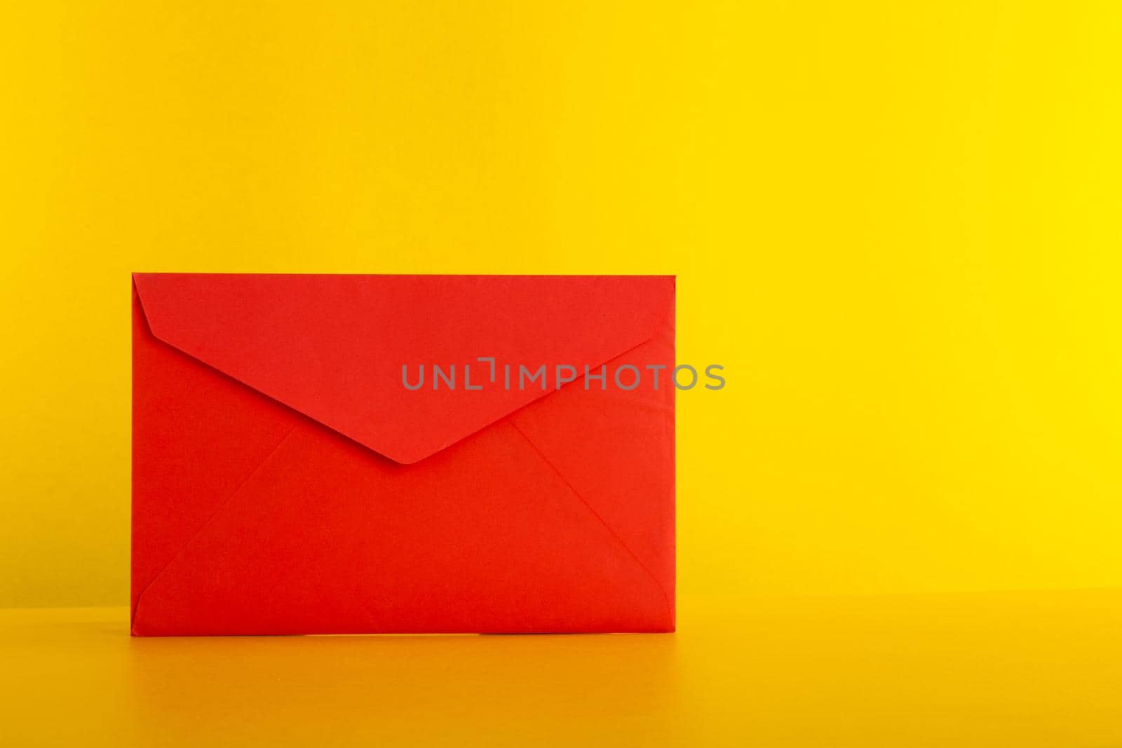 Colorful paper envelopes on yellow background - top view