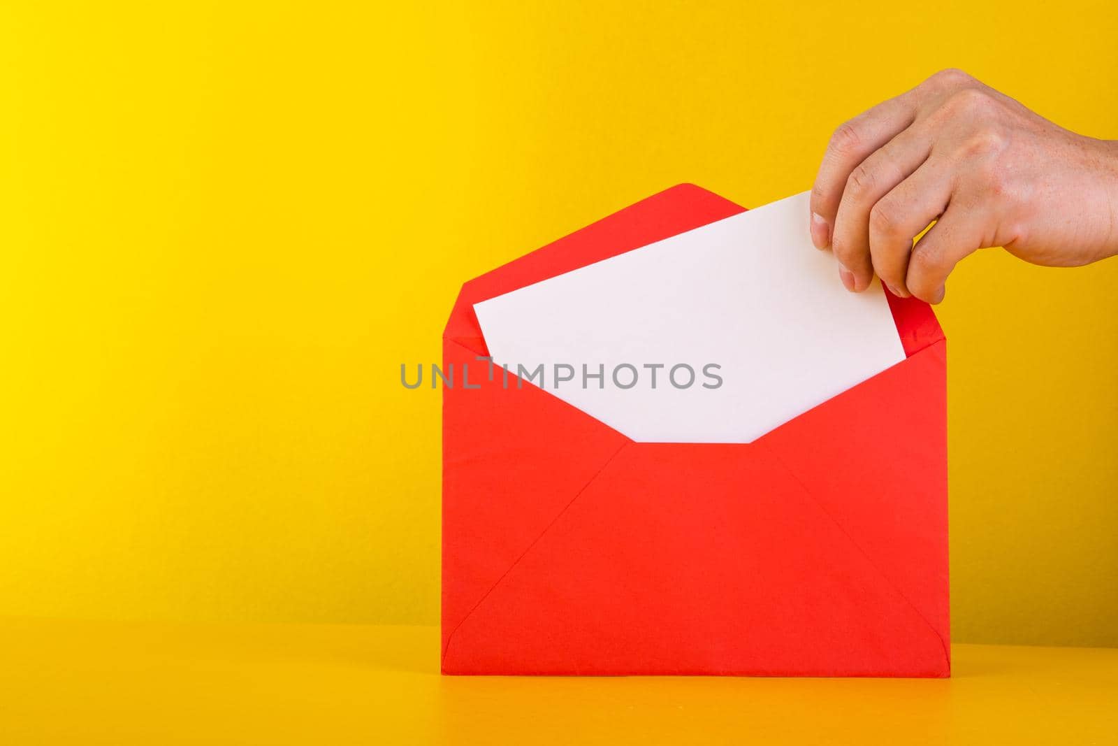 Colorful paper envelopes on yellow background - top view