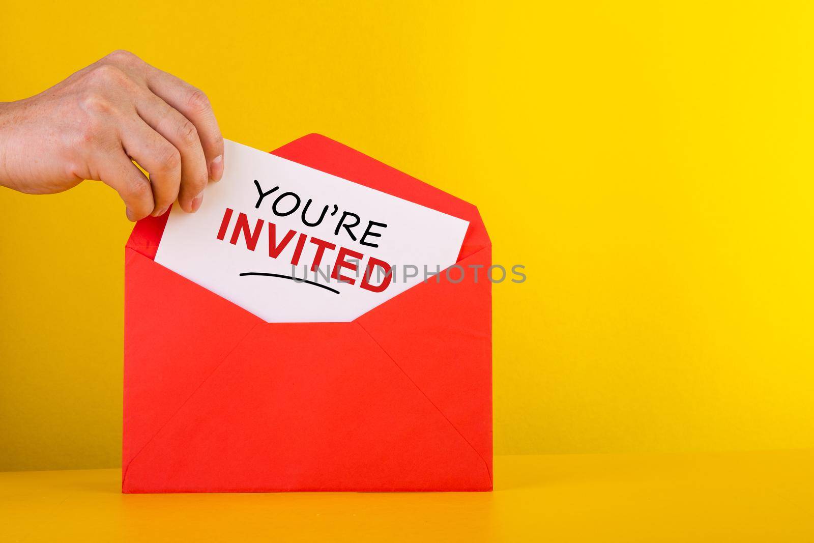 You're Invited Concepts - Hand holding a a card with red envelope.