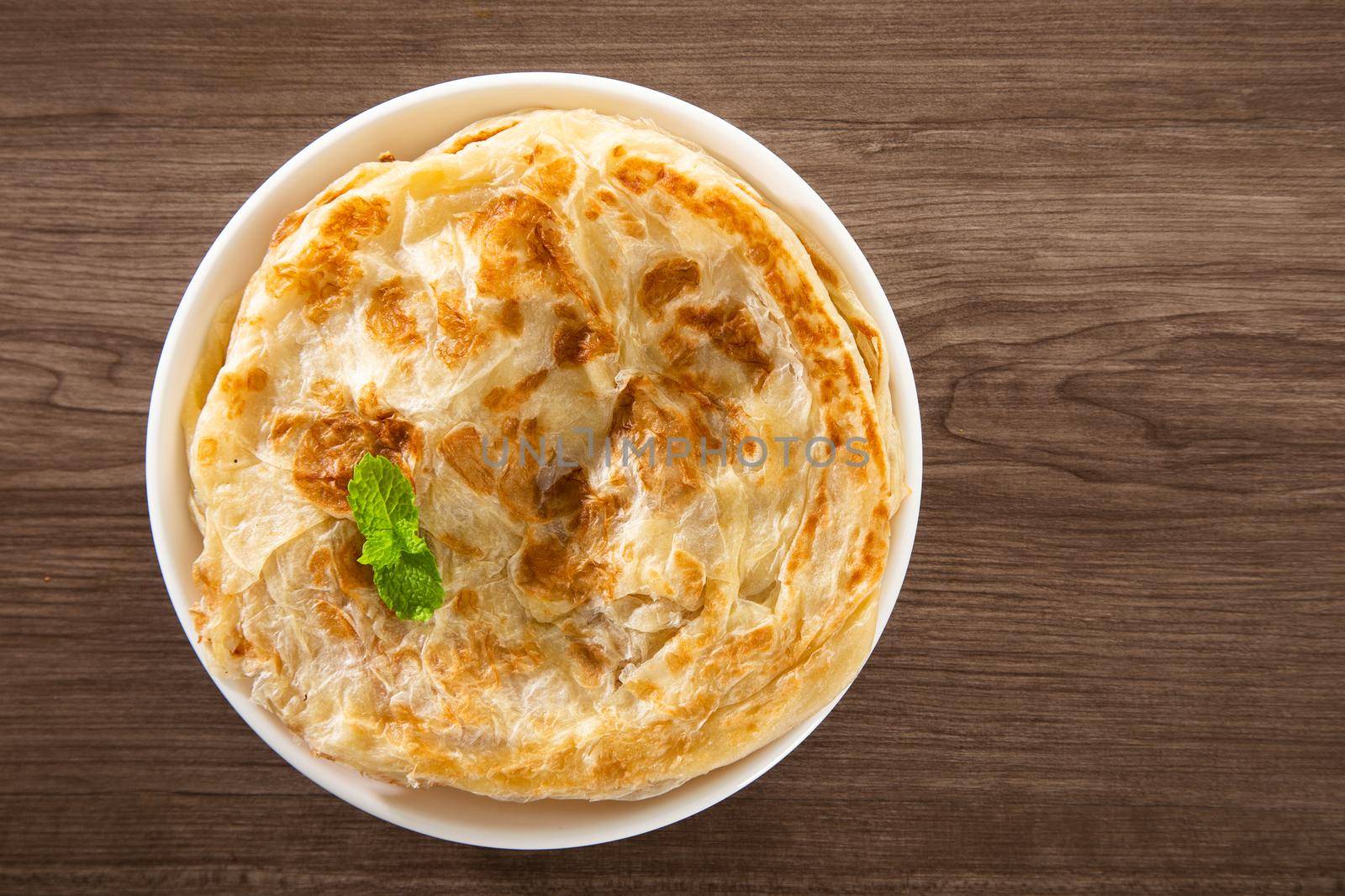 Roti Parata or Roti canai with lamb curry sauce - popular Malaysian breakfast