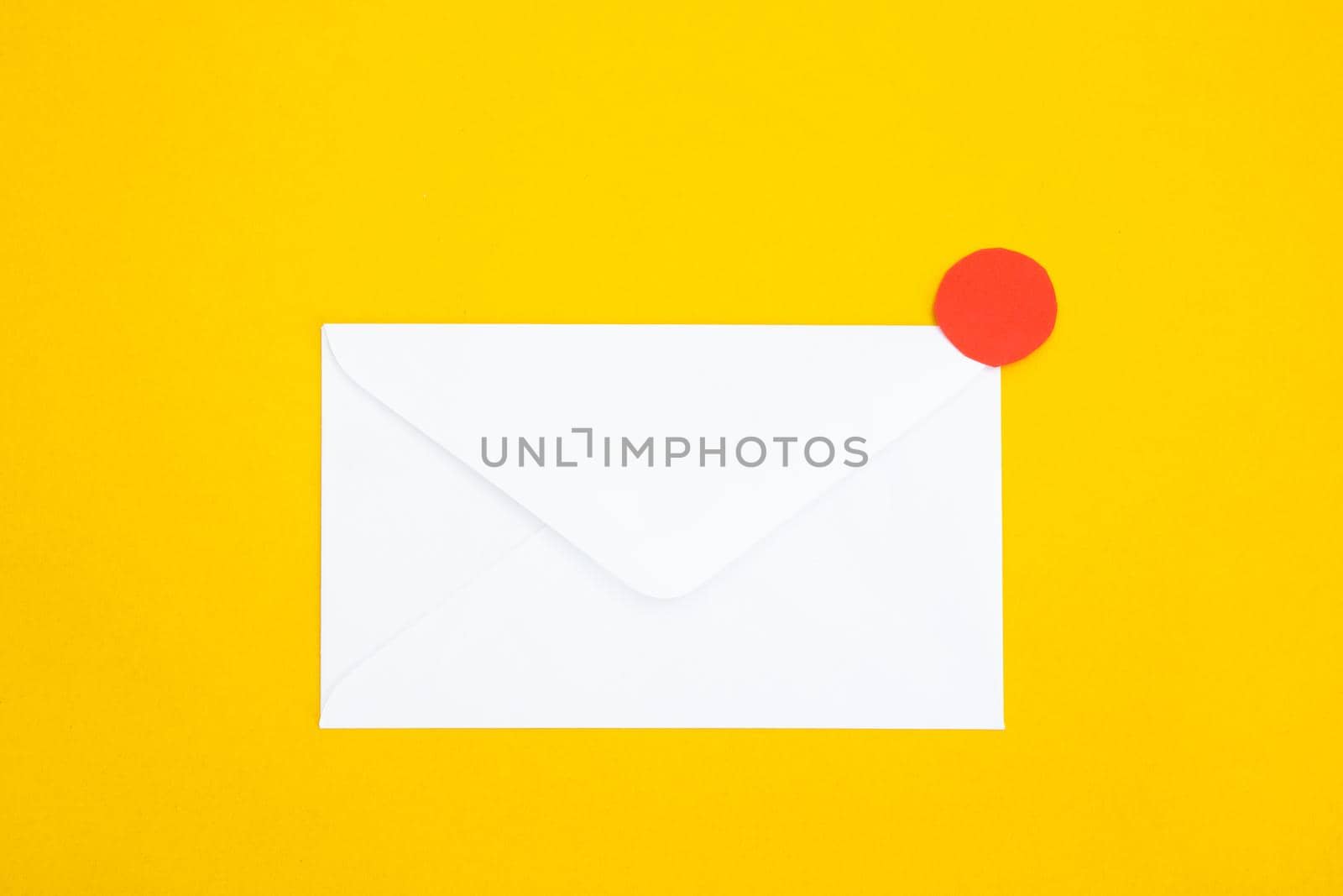 Colorful paper envelopes on yellow background - top view