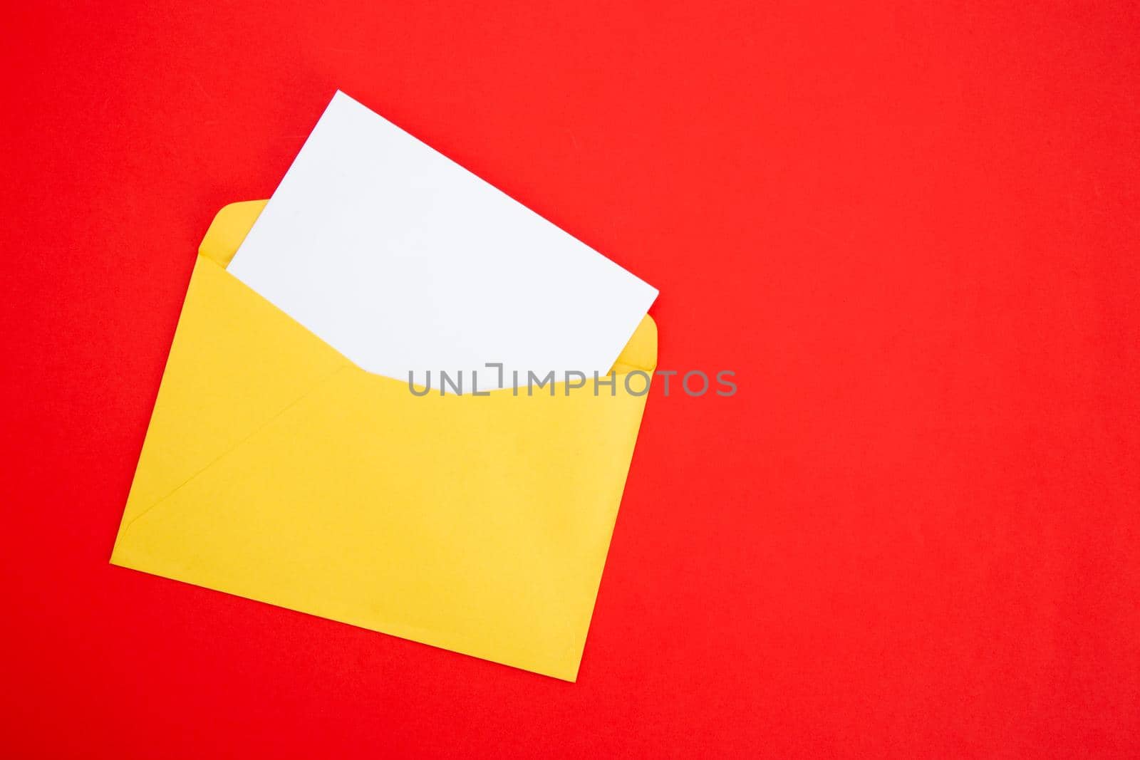 Colorful paper envelopes on red background - top view