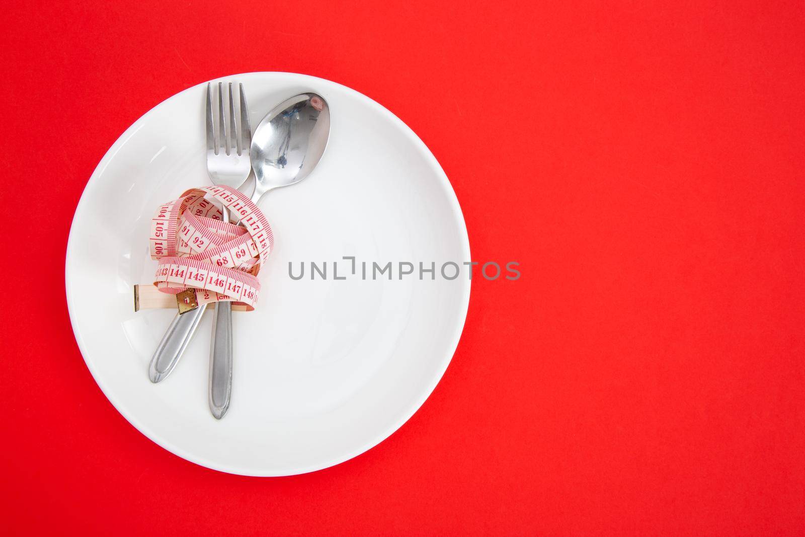 Measuring tape on a fork and knife - dieting concept