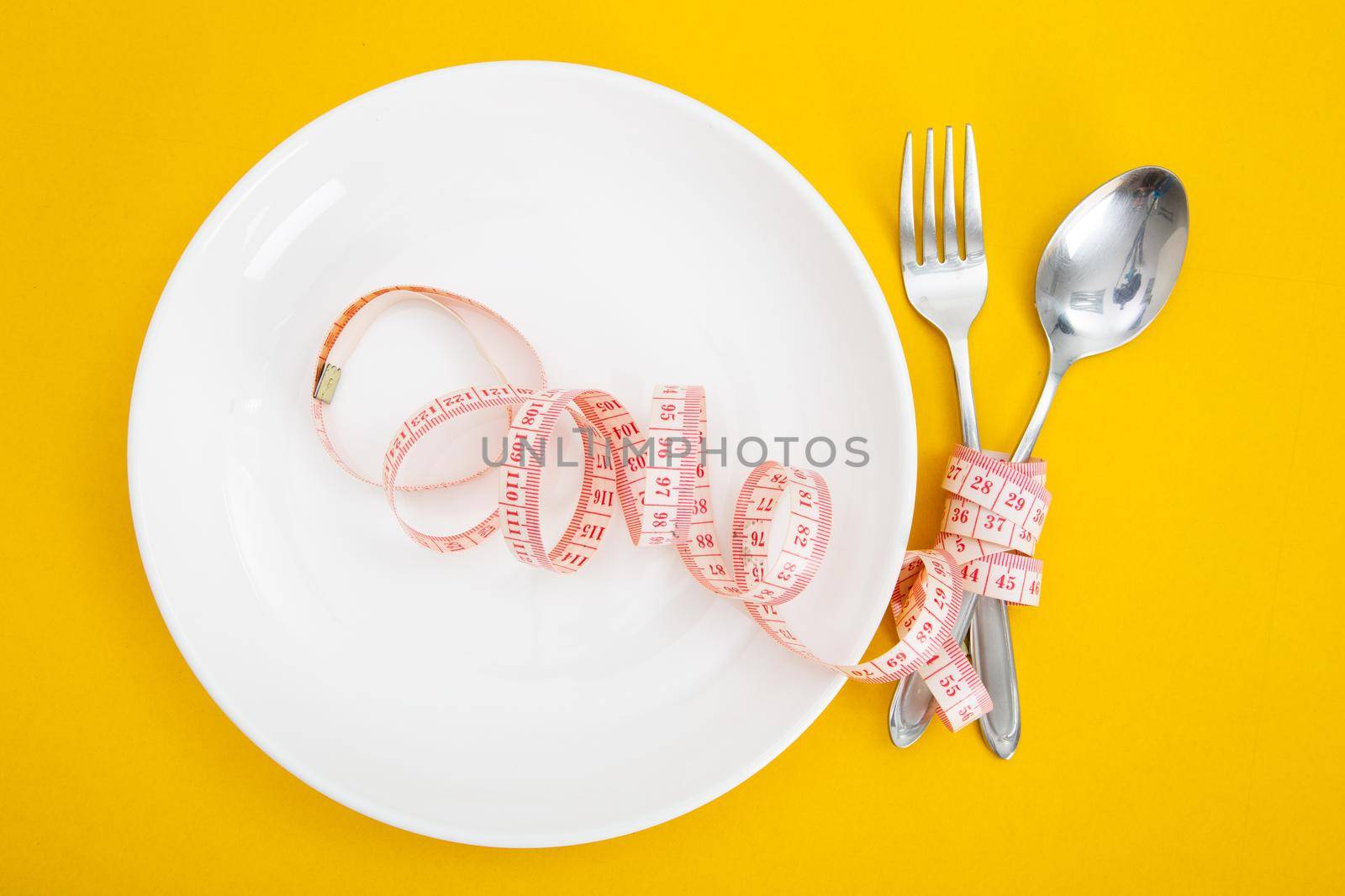 Measuring tape on a fork and knife - dieting concept