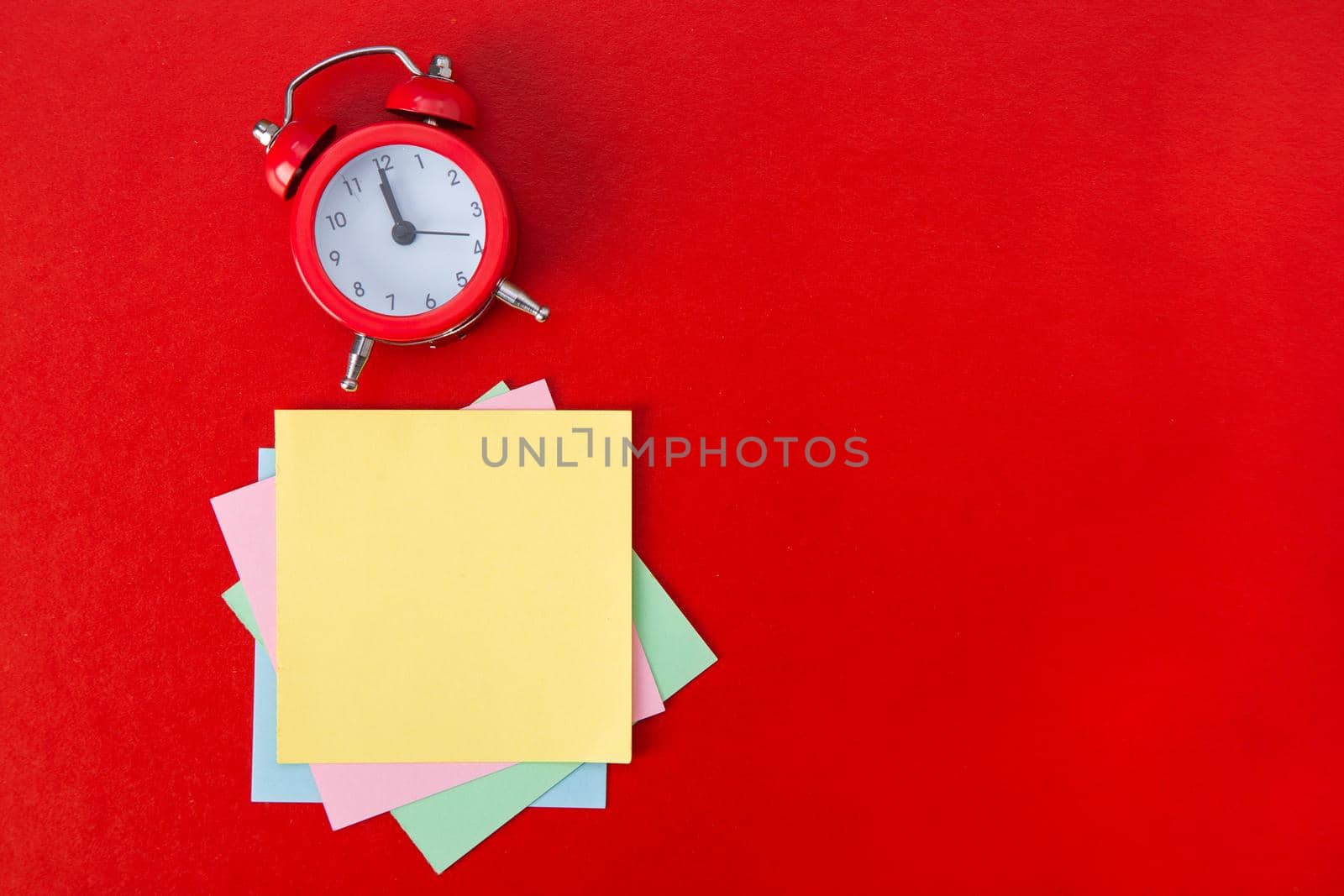Alarm clock on red background. Copy Space