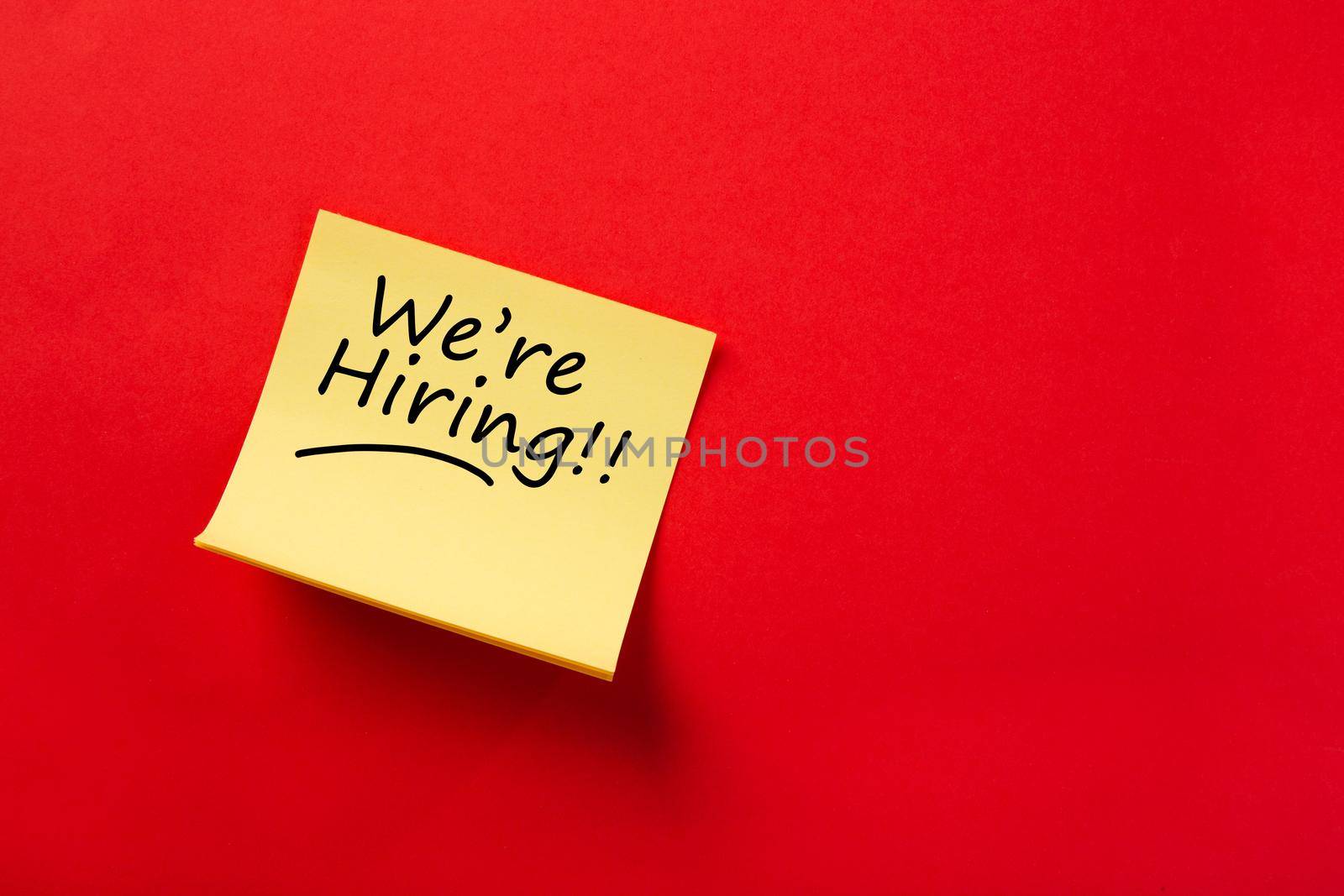 Sticky note on red background, We're hiring