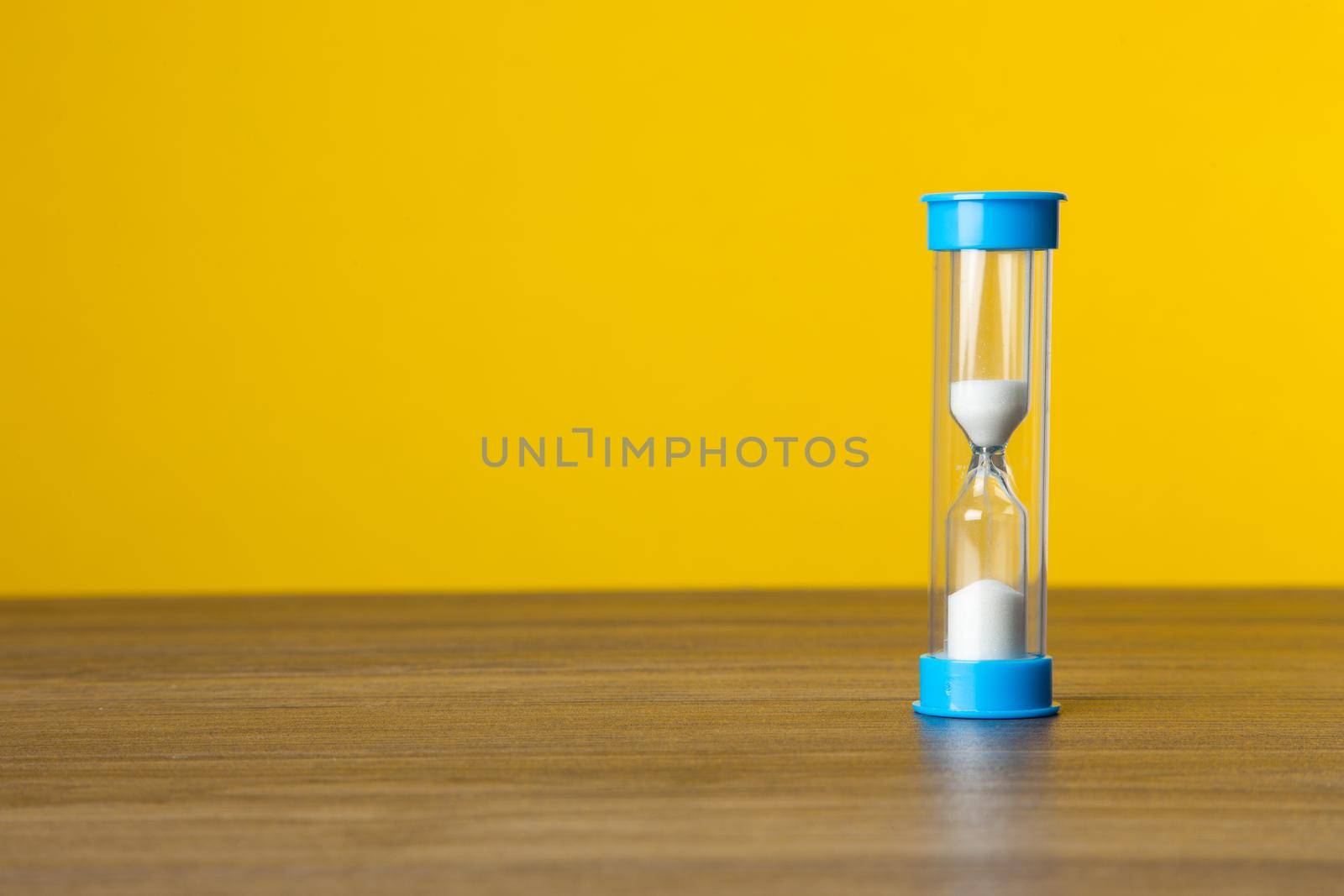 Time sand on yellow background. Time Concept