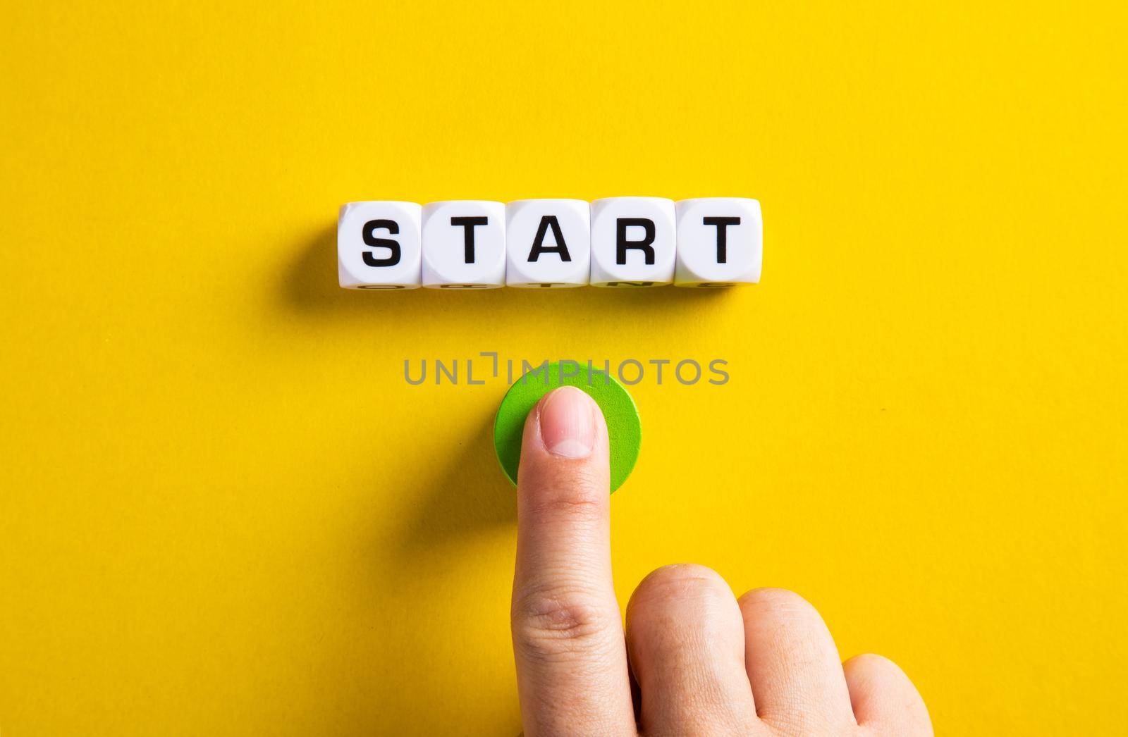 The word start on cubes with a male hand pressing the start button. To make a new start in life, business, education or career concept.
