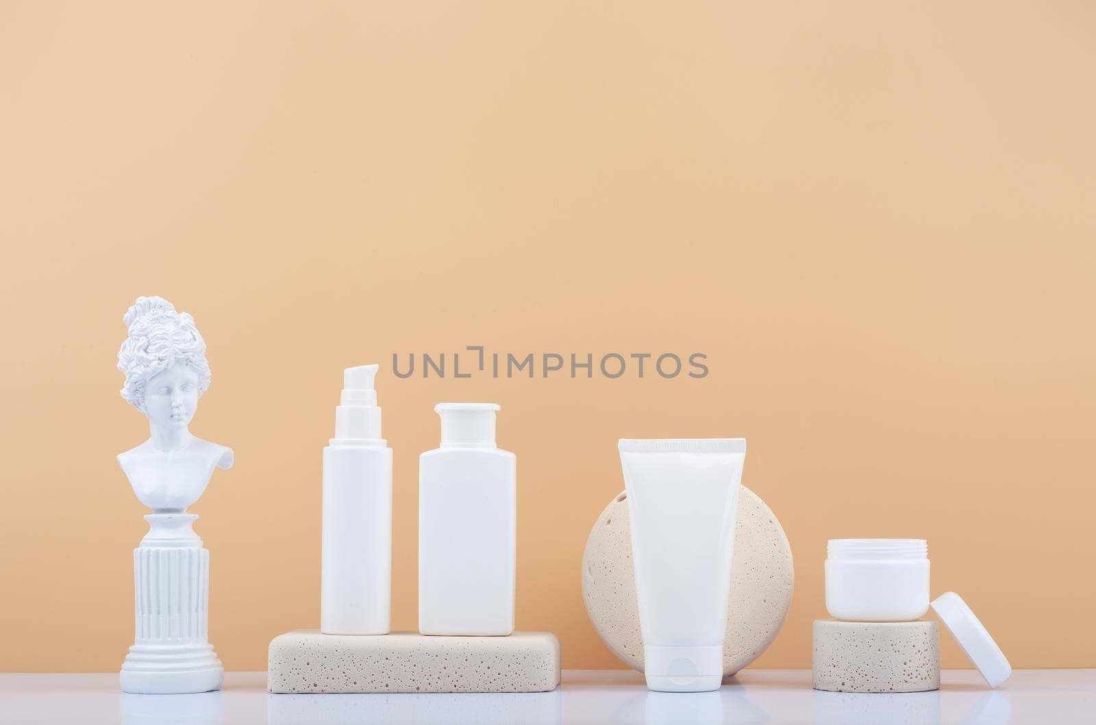 Set of skin care products with gypsum figure of a woman on white table against beige background with copy space by Senorina_Irina
