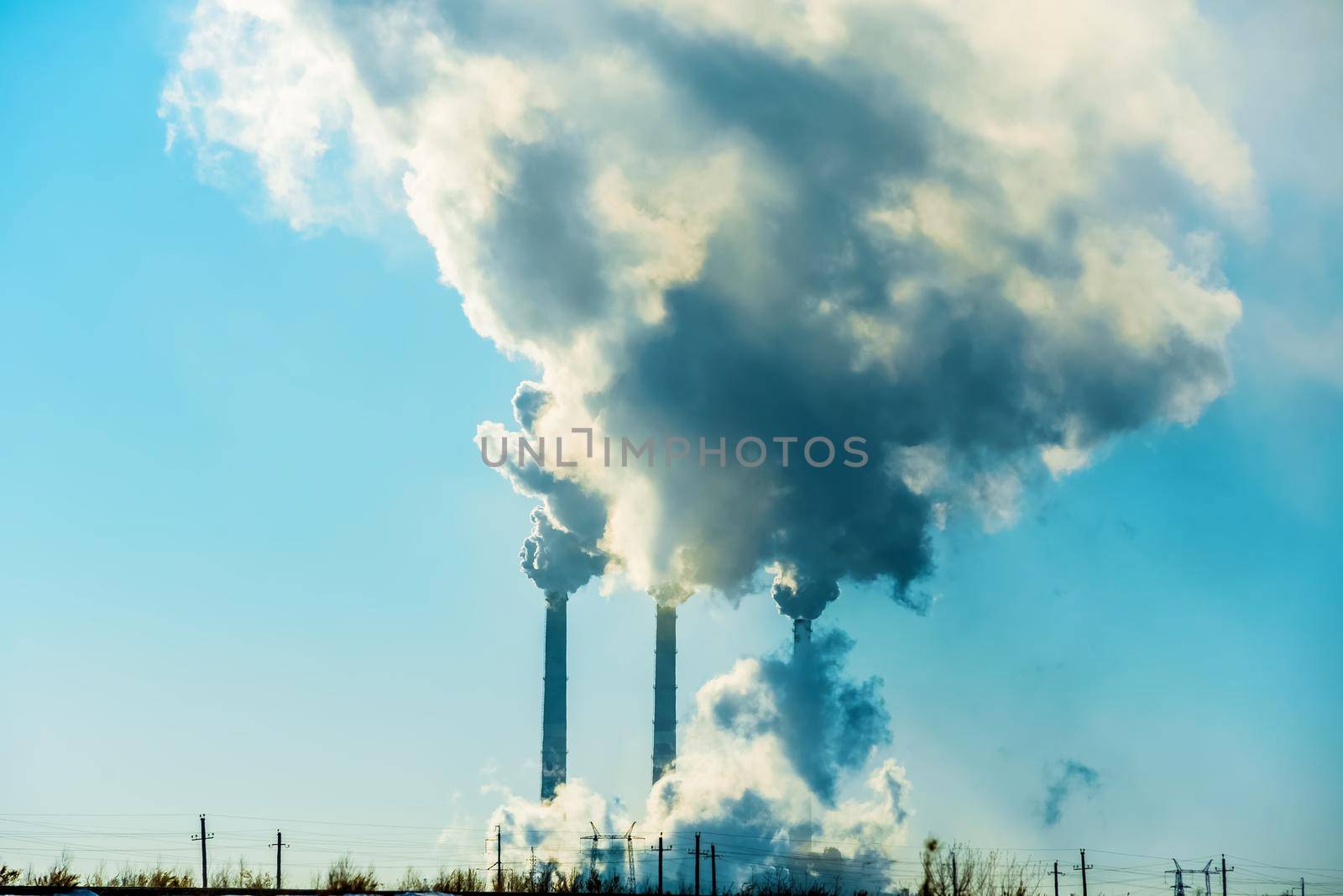 Smoking factory chimneys.Environmental problem of pollution of environment and air in large cities.Climate change,ecology and global warming.The sky is smoky with toxic substances.Soot from factories